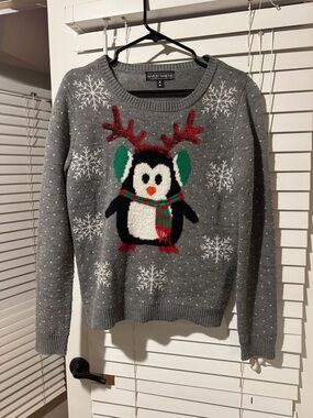 Almost Famous Gray Penguin Holiday Crewneck Sweater with Red & Green Accents.